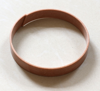 Phenolic aldehyde baffle ring coated with fabric